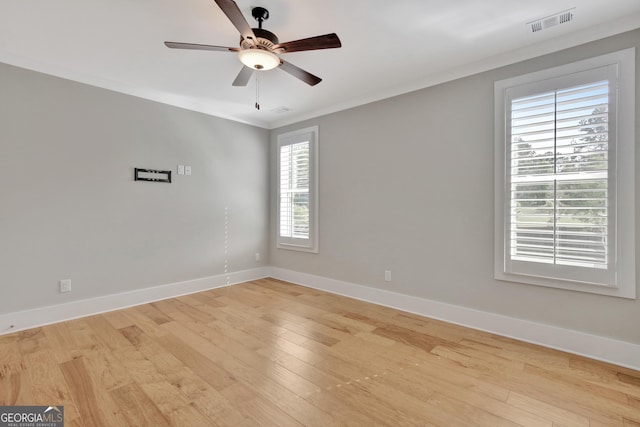 empty room featuring ceiling fan, light hardwood / wood-style floors, and crown molding