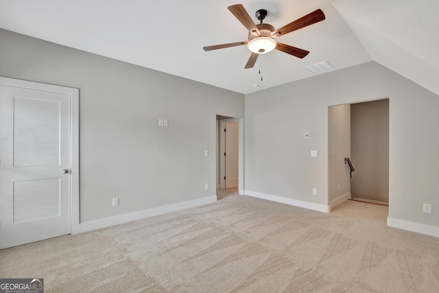 unfurnished bedroom featuring ceiling fan, vaulted ceiling, and light carpet