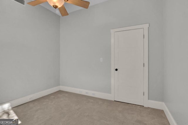 spare room featuring light colored carpet and ceiling fan