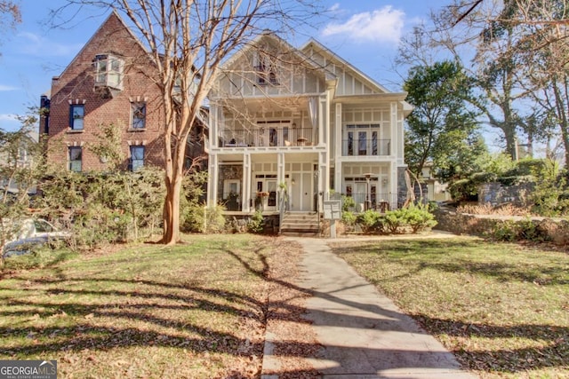 view of front of property featuring a balcony and a front yard