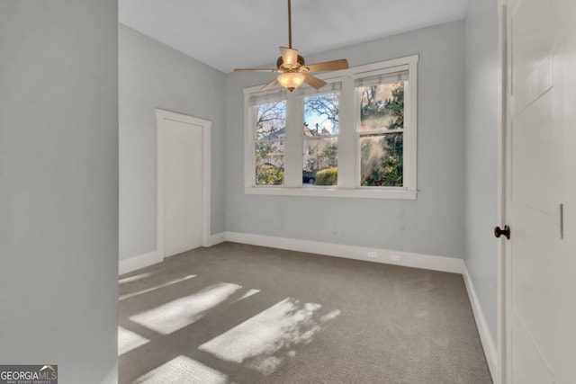 empty room featuring ceiling fan and carpet