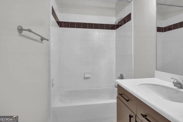 bathroom featuring tiled shower / bath combo and vanity