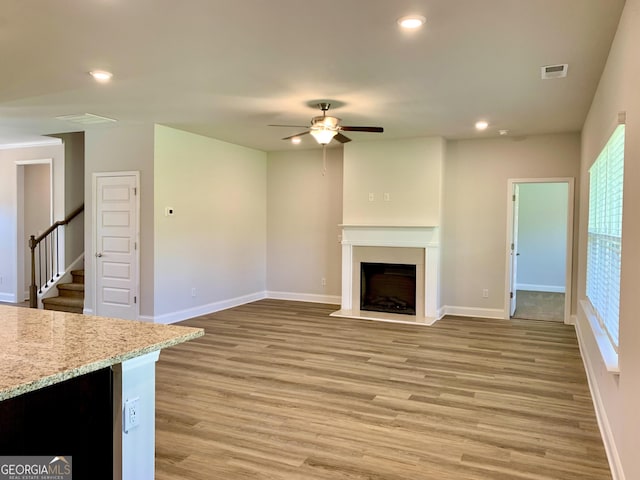 unfurnished living room with ceiling fan and hardwood / wood-style flooring