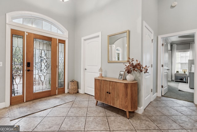 foyer with a high ceiling and light tile patterned floors