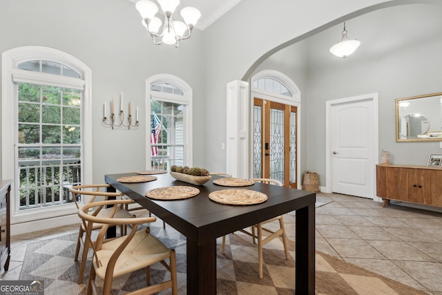 tiled dining room with a high ceiling, a notable chandelier, french doors, and crown molding