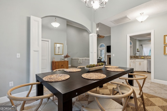 tiled dining area featuring a notable chandelier and sink