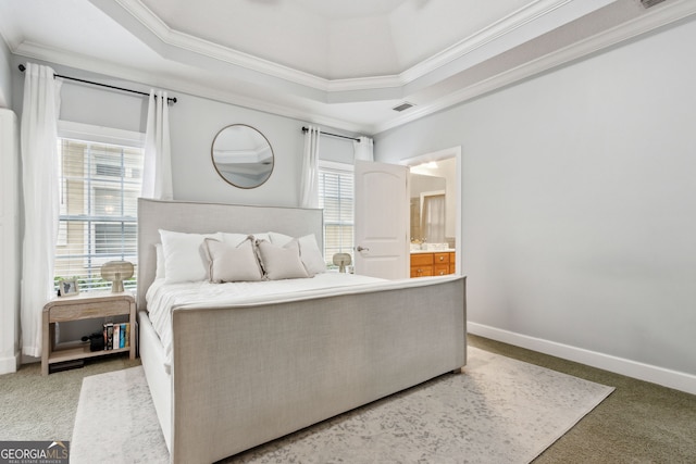 carpeted bedroom with connected bathroom, crown molding, and a tray ceiling