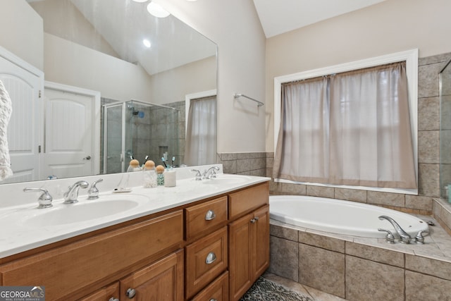 bathroom featuring vaulted ceiling, independent shower and bath, and vanity