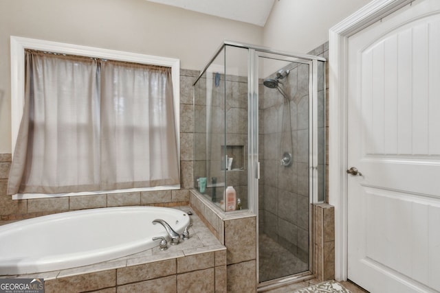 bathroom featuring shower with separate bathtub