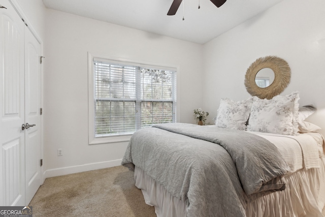 carpeted bedroom with ceiling fan and a closet