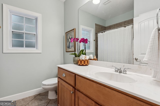 bathroom featuring vanity, tile patterned flooring, toilet, and walk in shower