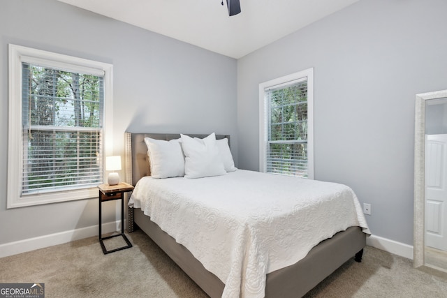 carpeted bedroom featuring ceiling fan and multiple windows