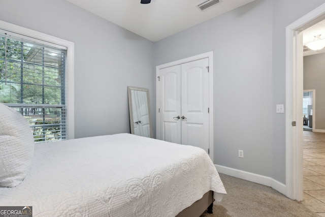 carpeted bedroom featuring ceiling fan and a closet