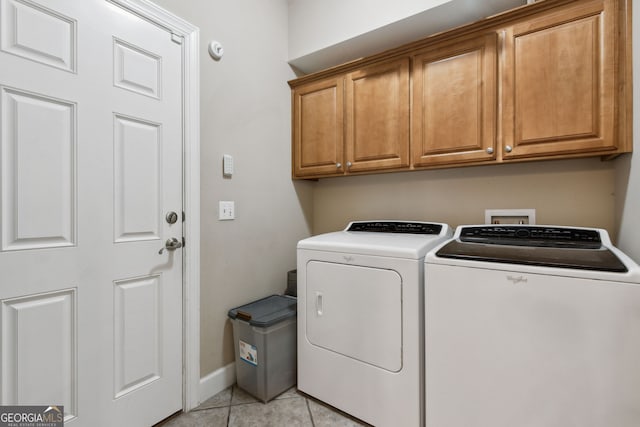 laundry area featuring cabinets, washer and clothes dryer, and light tile patterned floors