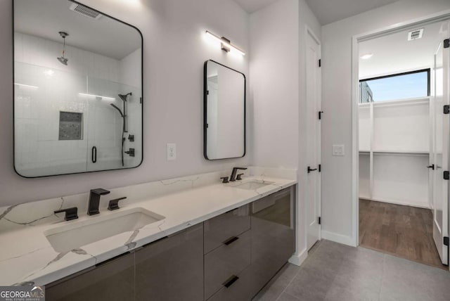 bathroom featuring vanity, tile patterned floors, and a shower with shower door