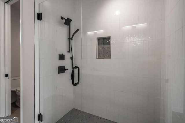 bathroom with toilet and an enclosed shower