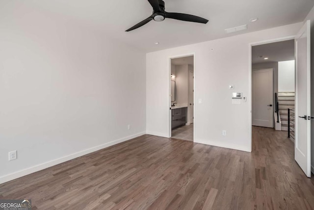 unfurnished bedroom with hardwood / wood-style flooring, ceiling fan, and ensuite bath