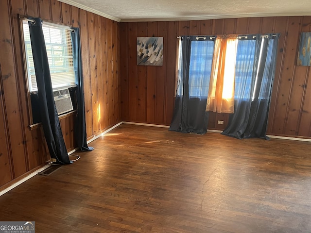 unfurnished room with a textured ceiling, dark hardwood / wood-style flooring, and wood walls