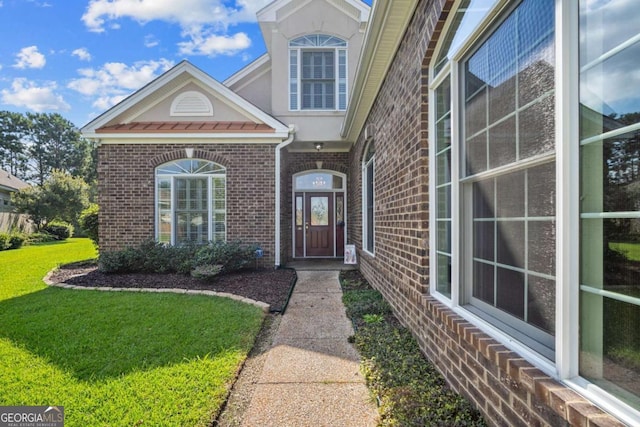 doorway to property with a lawn