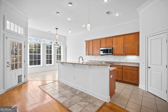 22 Lazy Hammock Ct, Savannah, GA 31419 - kitchen with a kitchen island with sink, crown molding, sink, decorative light fixtures, and light tile patterned flooring