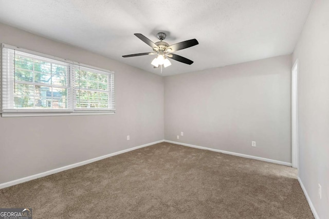 carpeted spare room featuring ceiling fan