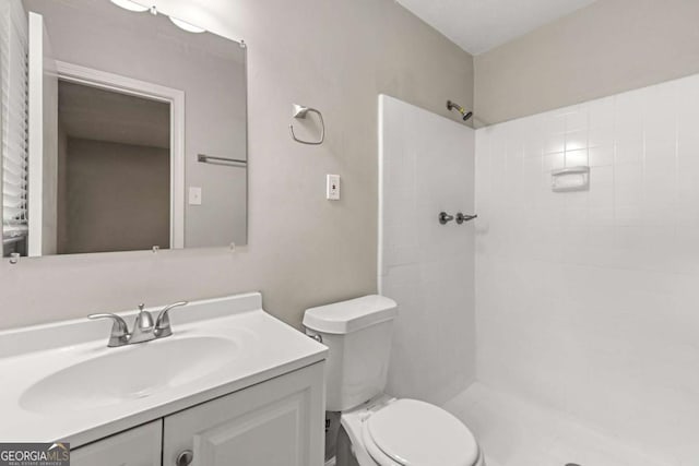 bathroom featuring walk in shower, vanity, and toilet