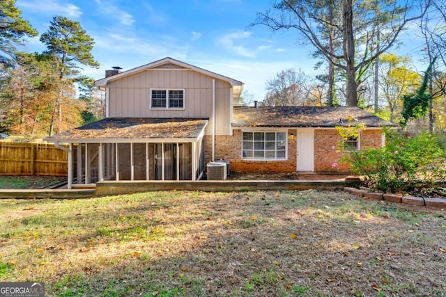 back of property with a yard, cooling unit, and a sunroom