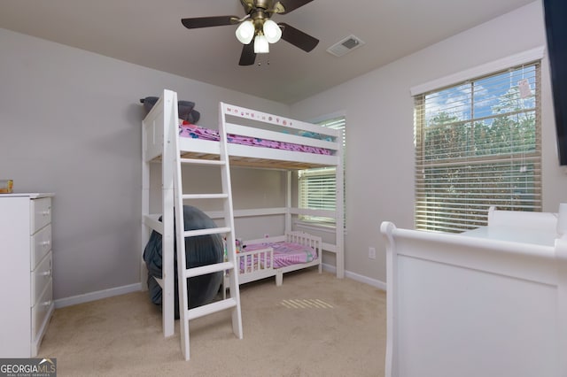 carpeted bedroom with multiple windows and ceiling fan