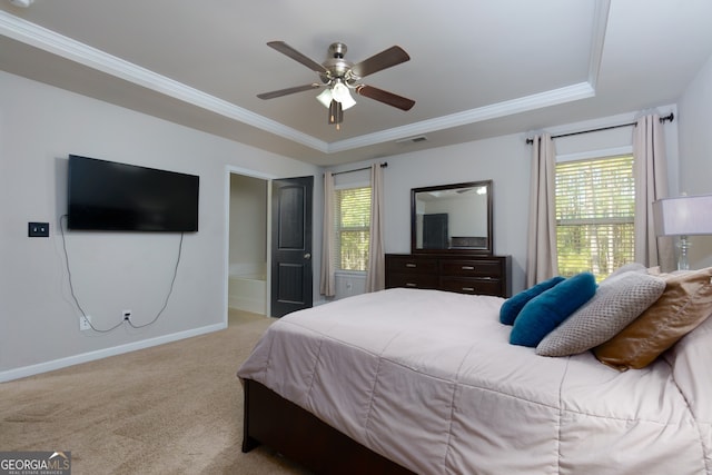 carpeted bedroom with ceiling fan, ornamental molding, and a tray ceiling