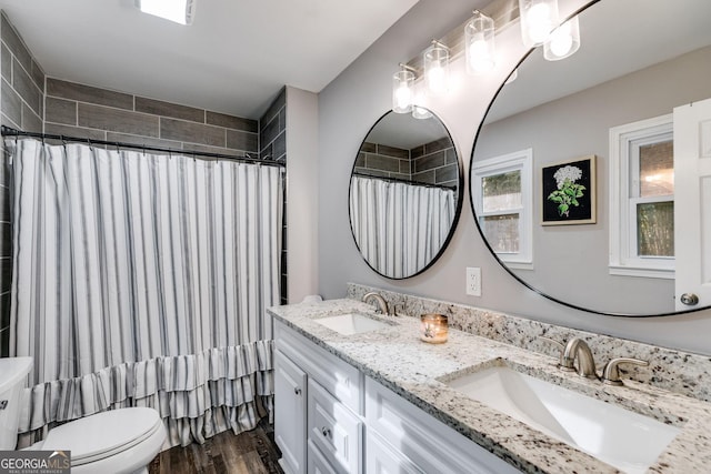 bathroom featuring toilet, vanity, hardwood / wood-style flooring, and walk in shower