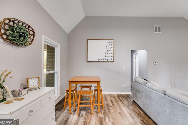 dining room with light hardwood / wood-style floors and lofted ceiling