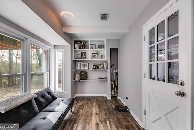 sitting room with dark hardwood / wood-style flooring, built in features, and beamed ceiling