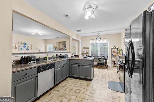 kitchen with kitchen peninsula, dishwasher, black fridge, gray cabinetry, and sink