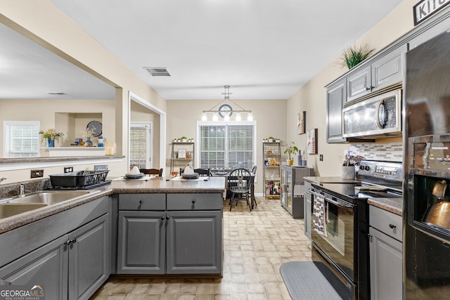 kitchen featuring black appliances, pendant lighting, backsplash, and gray cabinets