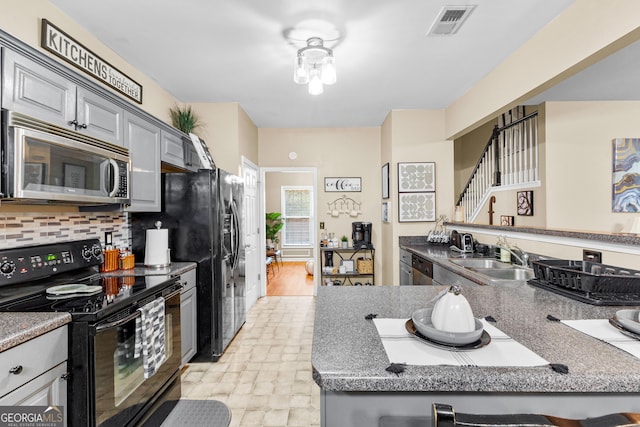 kitchen featuring sink, tasteful backsplash, black appliances, and gray cabinetry