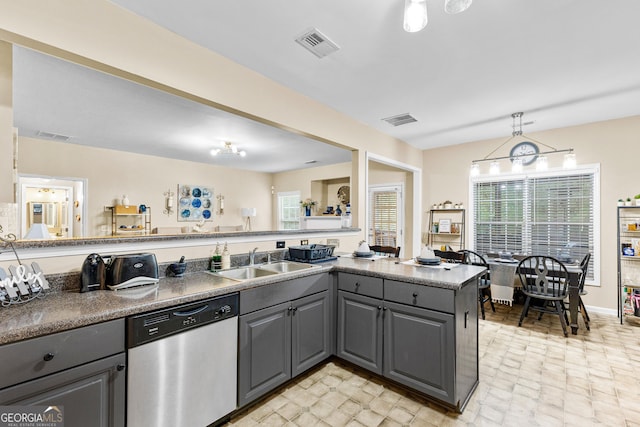 kitchen with kitchen peninsula, stainless steel dishwasher, hanging light fixtures, gray cabinets, and sink