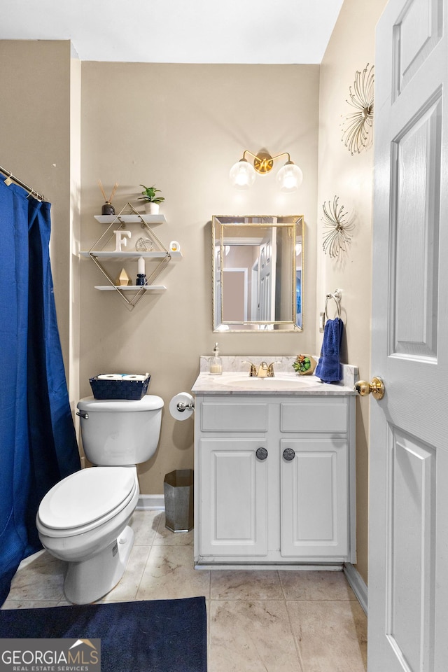 bathroom featuring tile patterned flooring, vanity, and toilet