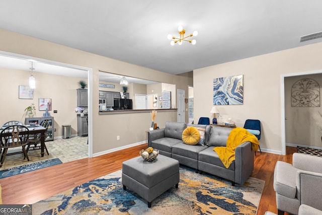 living room with hardwood / wood-style flooring and an inviting chandelier