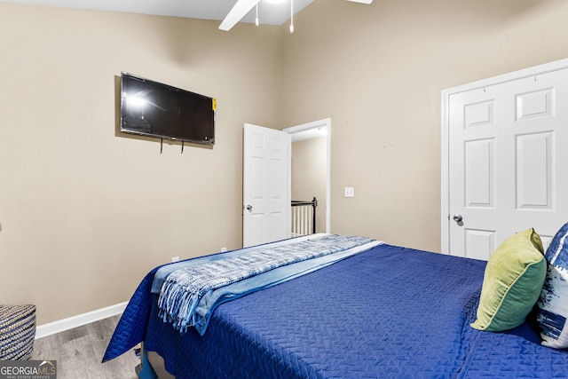 bedroom with a high ceiling, ceiling fan, and hardwood / wood-style floors