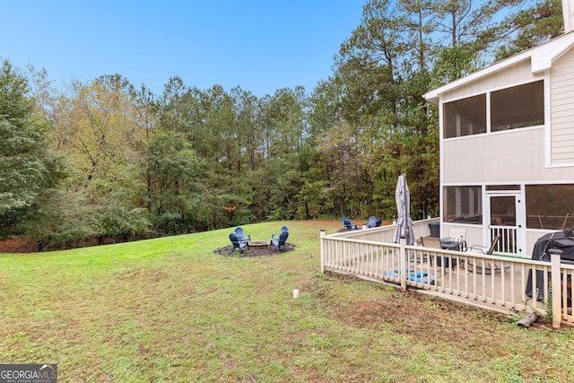 view of yard featuring an outdoor fire pit and a sunroom