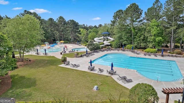 view of swimming pool with a patio and a lawn