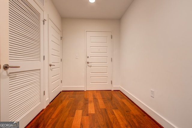 hallway with dark hardwood / wood-style flooring