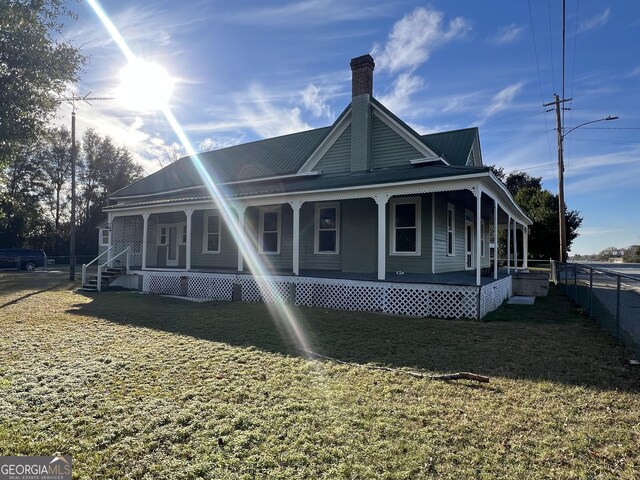 view of front of home with covered porch and a front lawn