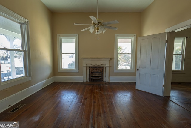 unfurnished living room featuring ceiling fan and dark hardwood / wood-style floors