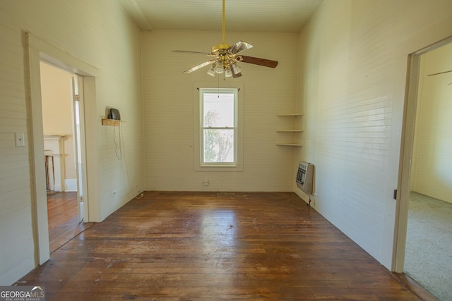 interior space with ceiling fan, dark hardwood / wood-style flooring, and heating unit