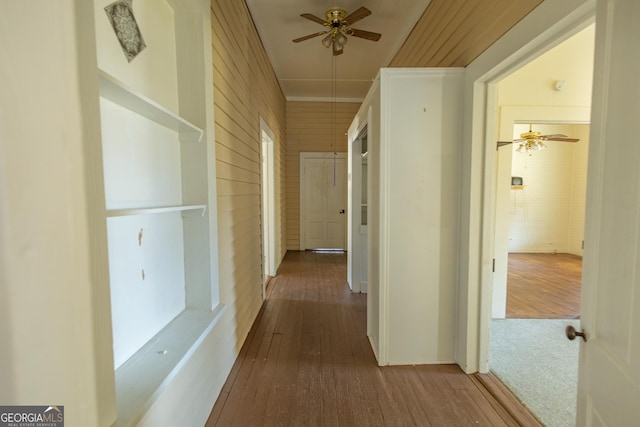 corridor with hardwood / wood-style floors and crown molding