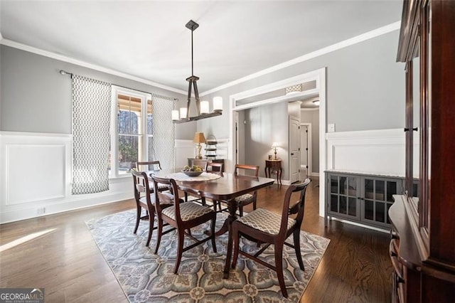 dining room featuring a notable chandelier, ornamental molding, and dark hardwood / wood-style flooring