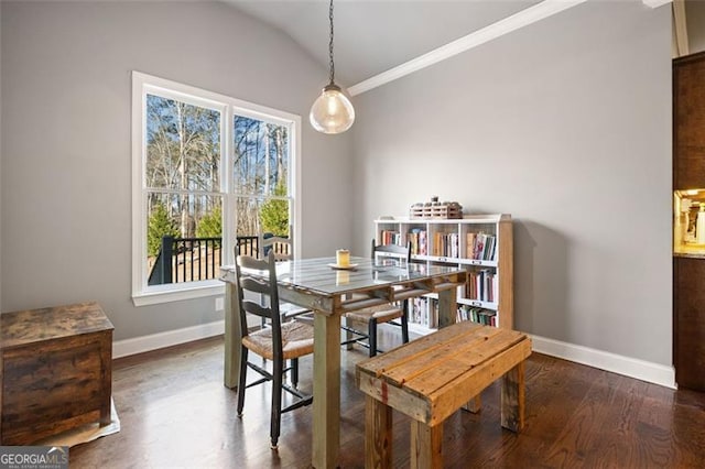 dining area featuring dark wood-type flooring, lofted ceiling, plenty of natural light, and crown molding