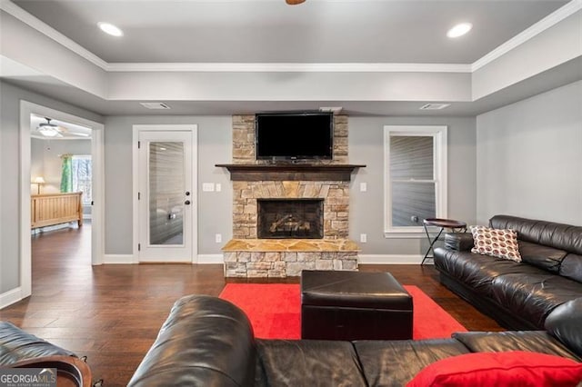 living room with a fireplace, ceiling fan, crown molding, and dark hardwood / wood-style floors