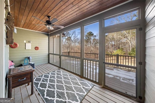 sunroom / solarium with a healthy amount of sunlight, ceiling fan, and wood ceiling